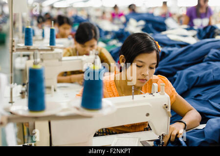 Lavoratori asiatici cucire vestiti in fabbrica di indumento Foto Stock