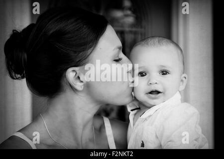 Close up razza mista madre kissing baby figlio Foto Stock