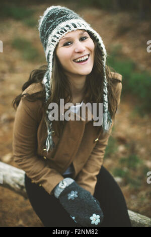 Caucasian donna seduta sul registro di legno Foto Stock