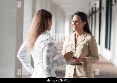 Imprenditrici parlando in corridoio Foto Stock