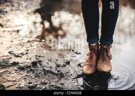 Close up della donna in piedi nella pozza Foto Stock