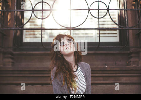 Caucasian donna in piedi sotto la finestra Foto Stock