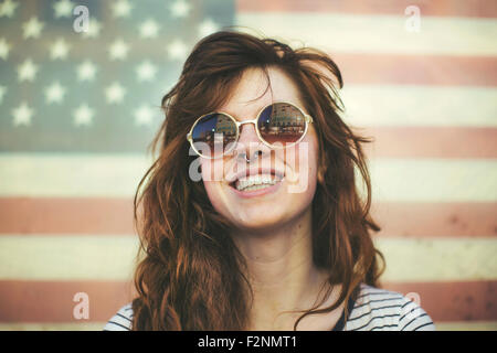 La donna caucasica indossando occhiali da sole a bandiera americana Foto Stock