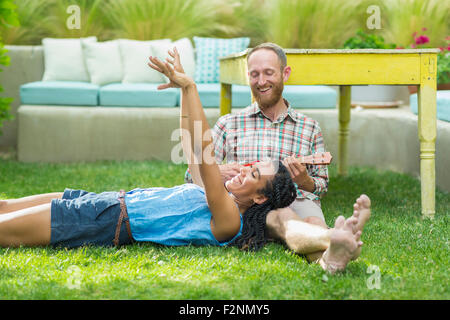 Giovane rilassante in cortile Foto Stock