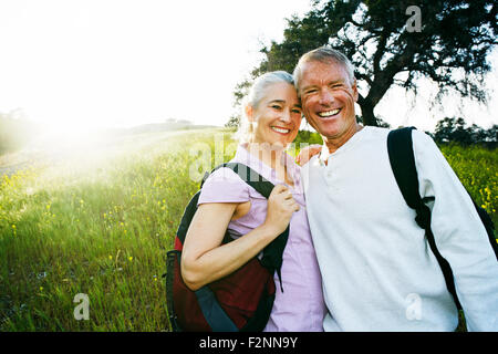 Caucasian Coppia sorridente in erba alta Foto Stock