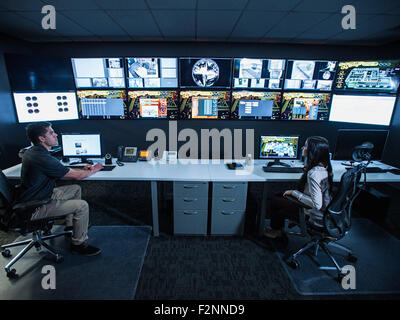 Le guardie di sicurezza a guardare i monitor in sala di controllo Foto Stock