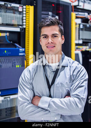 Tecnico ispanica sorridente in sala server Foto Stock