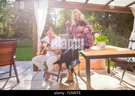 La famiglia in relax sulla terrazza del cortile Foto Stock