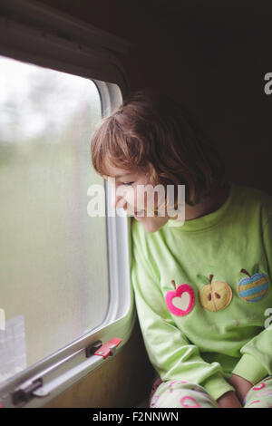 Ragazza caucasica a guardare fuori dalla finestra del treno Foto Stock