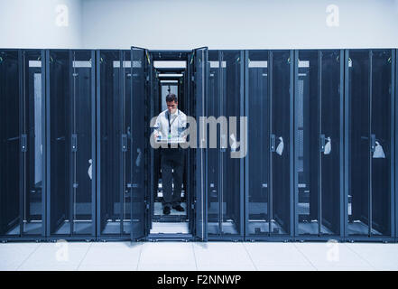 Ispanico tecnico che lavora in sala server Foto Stock