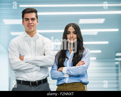 La gente di affari in piedi con le braccia piegate in ufficio Foto Stock