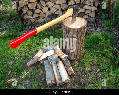 Ax sul blocco di trinciatura con un trito di log Foto Stock