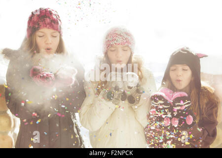 Ragazze caucasica lavori di soffiaggio della neve off mittens Foto Stock