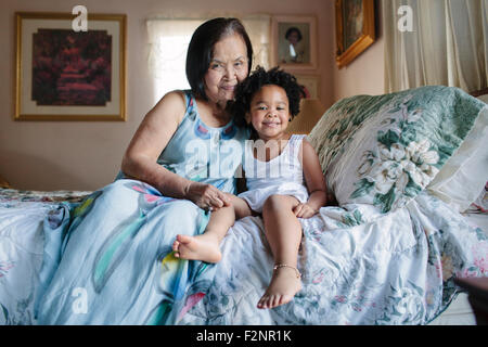 Nonna e nipote abbracciando sul letto Foto Stock