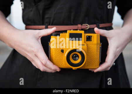 Close up Nero donna tenendo la fotocamera in plastica Foto Stock