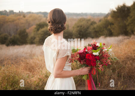 Sposa bouquet di contenimento sulla collina rurale Foto Stock