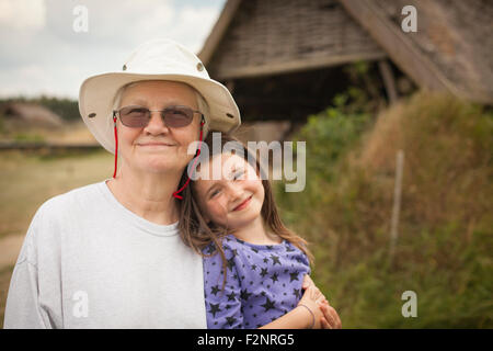 Nonna caucasica abbracciando la nipote in cortile Foto Stock