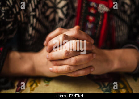Womans mani giunte in preghiera Foto Stock