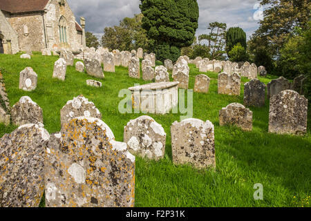 Church Graveyard with old gravestones or tombstones covered in algae and lichen Foto Stock