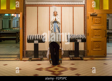 Il vecchio uomo prostating prima vergine Maria statua, nella Basilica di Sainte-Anne de Beaupré in Quebec, Canada. Foto Stock