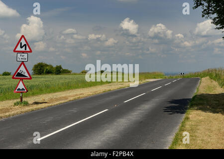 Una strada di campagna avvicinando una brusca curva. Foto Stock