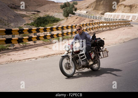 India, Jammu e Kashmir, Ladakh, Nimoo, Bazco uomo senza casco in sella Royal Enfield Bullet moto sui Kargil a Leh autostrada Foto Stock