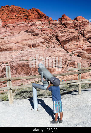 Ragazzo cerca attraverso il telescopio per ottenere una buona vista della Red Rock Canyon National Conservation Area, circa 20 miglia dal Las Vegas Foto Stock