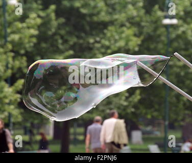 Gigantesche bolle di sapone creato con funi e bastoni in un parco Foto Stock