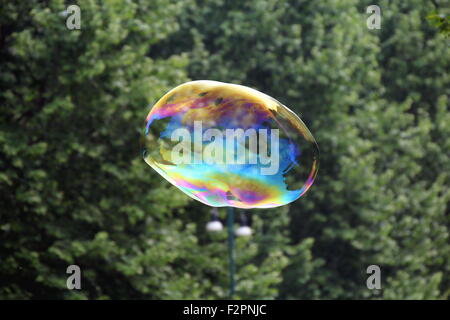 Gigantesche bolle di sapone creato con funi e bastoni in un parco Foto Stock