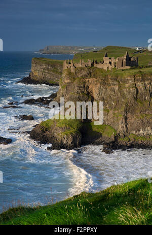 Sera La luce del sole sopra le rovine del Dunluce Castle e le scogliere della contea di Antrim, Irlanda del Nord, Regno Unito Foto Stock