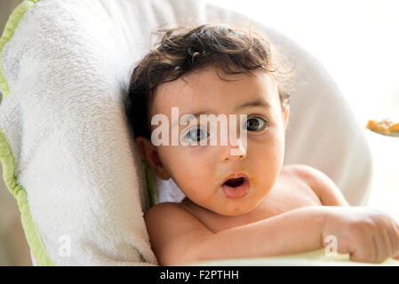 A pranzo o a cena per i bambini nella sua sedia alta Foto Stock