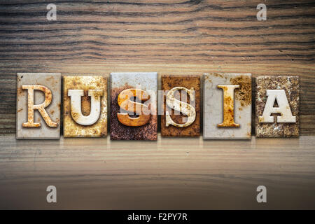 La parola " Russia " scritto in metallo arrugginito rilievografia tipo seduto su un listello di legno dello sfondo. Foto Stock