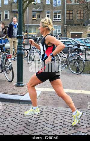 La 65th edition porta Dwars Dordt domenica 1 aprile 2012. Runner di sesso femminile che corre attraverso il centro di Dordrecht Foto Stock