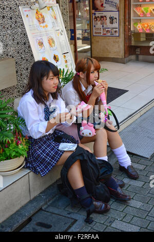 Due studentesse avente un morso. Harajuku di Tokyo. Foto Stock