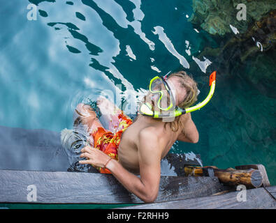 Giovane uomo lo snorkeling in chiaro poco profondo mare tropicale Foto Stock