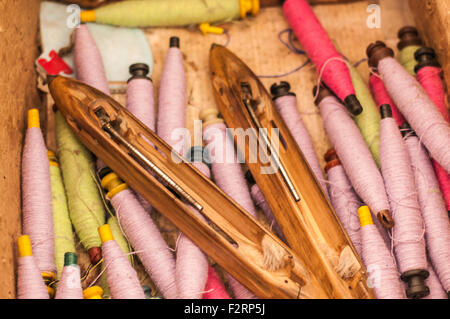 Un mucchio di telaio navette e bobine di filato. Foto Stock