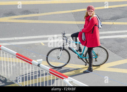 Ragazza su una bici in attesa presso il passaggio a livello cancelli in Inghilterra, Regno Unito. Foto Stock