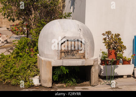 Tradizionale greco cipriota e legno cotto in forno di argilla in taverna all'aperto. Cucina mediterranea. Zygi. Cipro. Foto Stock