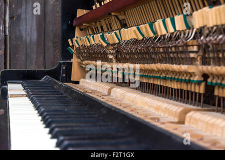 Vecchio pianoforte. Chiavi e piccoli martelli con messa a fuoco selettiva e profondità di campo. Foto Stock