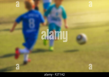 Ragazzi che giocano a calcio, defocussed blur sport immagine di sfondo Foto Stock