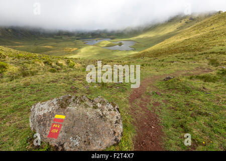 Modo giusto simbolo per gli escursionisti in Caldeirao, l'ultima eruzione pliniana sull isola di Corvo, come si vede dal bordo del cratere Foto Stock