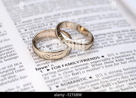 Gli anelli di nozze su un dizionario pagina che mostra la definizione di amore, close up Foto Stock