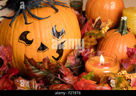 Dipinto la faccia di zucca con lo zucchero zucche e una candela accesa per una Decorazione Halloween impostato Foto Stock