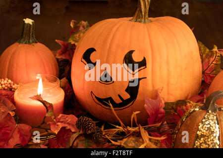 Dipinto la faccia di zucca con lo zucchero zucche e un lig candela per una Decorazione Halloween impostato Foto Stock