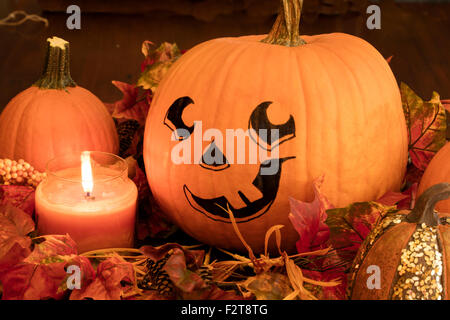 Dipinto la faccia di zucca con lo zucchero zucche e un lig candela per una Decorazione Halloween impostato Foto Stock