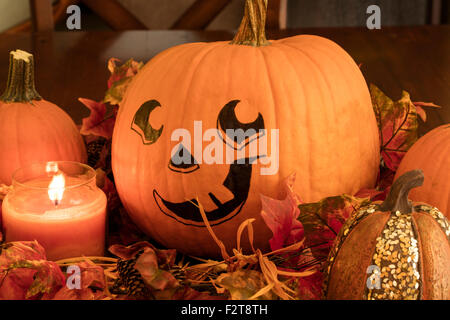 Dipinto la faccia di zucca con lo zucchero zucche e un lig candela per una Decorazione Halloween impostato Foto Stock