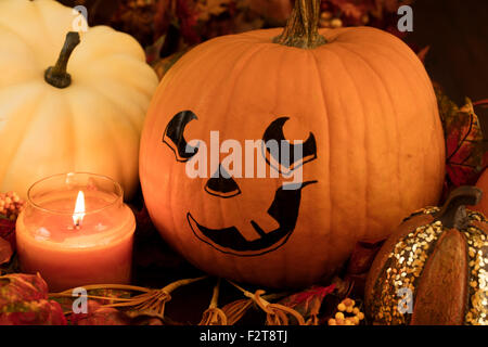 Dipinto la faccia di zucca con lo zucchero zucche e un lig candela per una Decorazione Halloween impostato Foto Stock