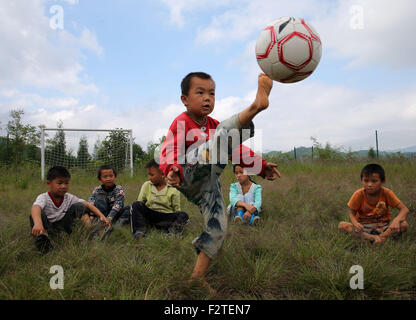 Chongqing, della Cina di Chongqing. 23 Sep, 2015. Una pupilla calci un calcio in cielo al villaggio Hongxing Scuola Elementare di Nanmu township di Youyang Tu e Miao contea autonoma, a sud-ovest della Cina di Chongqing, Sett. 23, 2015. Il villaggio di Hongxing scuola elementare, che ha solo 12 di primo grado gli alunni e un insegnante, è stata a lungo la mancanza di strutture sportive. Un'organizzazione caritativa in aprile ha contribuito palloni da calcio, obiettivi e recinti di passo per la scuola, che hanno portato la gioia per gli alunni. © Yang Min/Xinhua/Alamy Live News Foto Stock