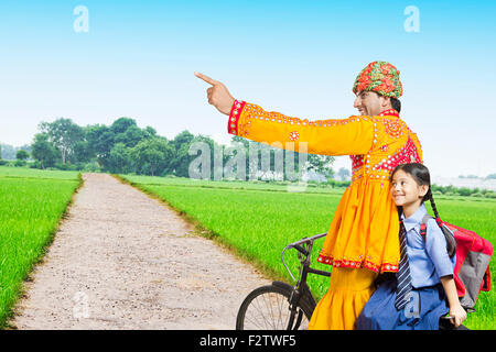 2 indiano abitante di Rajasthani padre e daughte fattoria equitazione Bicicletta puntare il dito che mostra Foto Stock