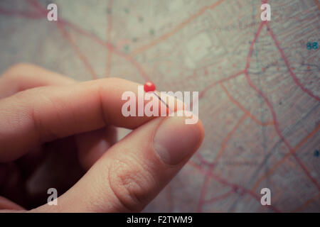 Close up su una mano collocando un perno su una mappa Foto Stock